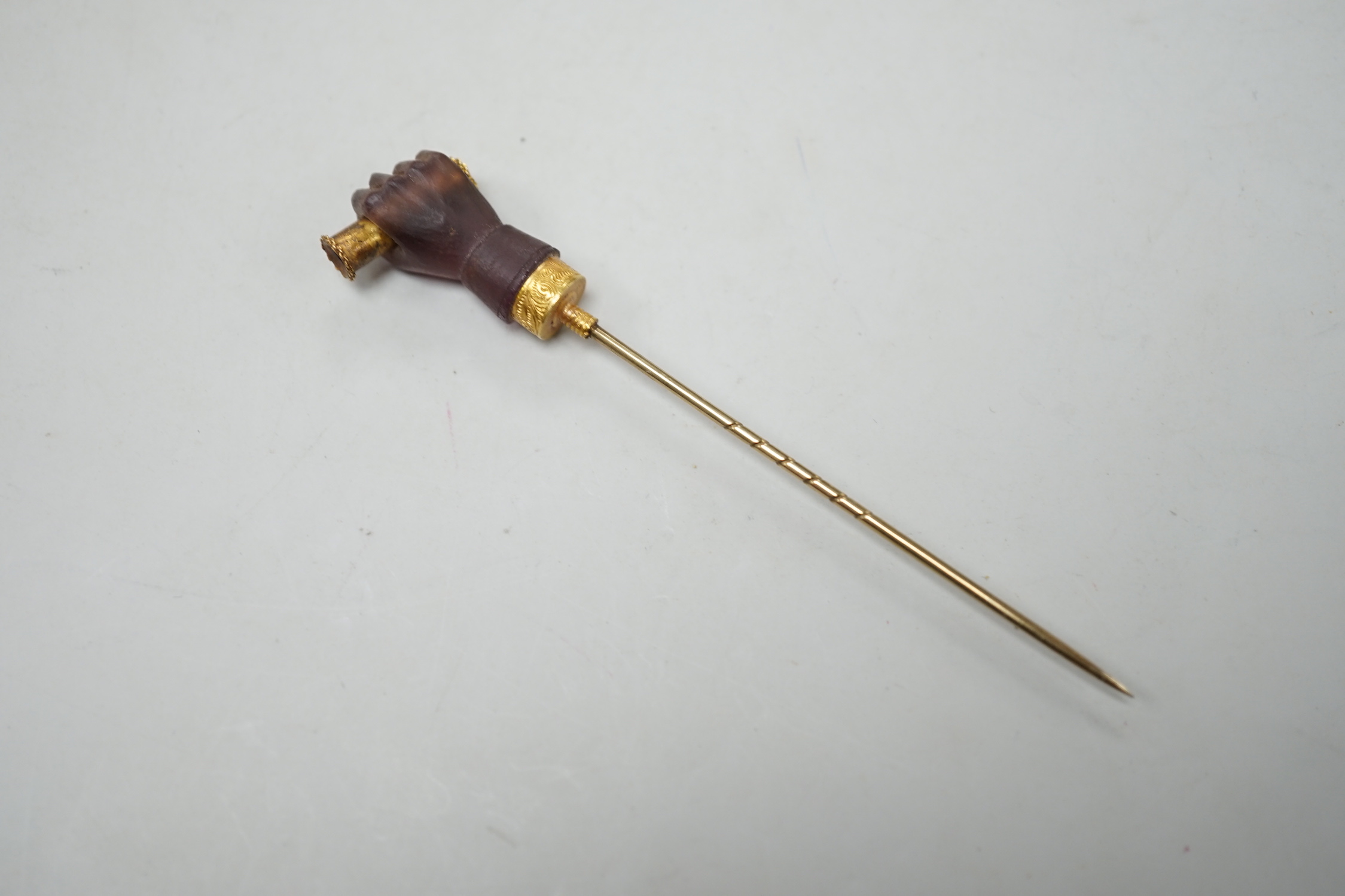 A cased 19th century yellow metal and amethyst glass? set Stanhope stick pin, modelled as hand holding a spyglass, 85mm, the lens depicting the bust of military? gentleman.